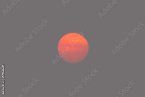 Orange sun disk isolated on smoky sky © Dushlik