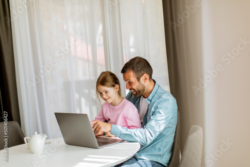 Father and daughter using laptop computer together © BGStock72