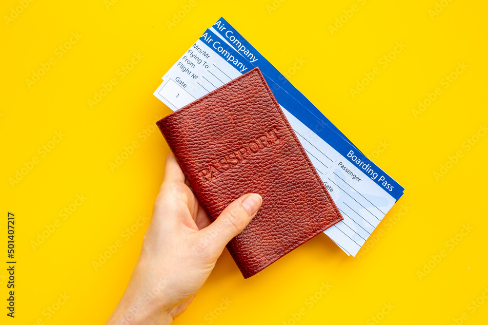 Hand holding passport with tickets - passport control at border - obrazy, fototapety, plakaty 