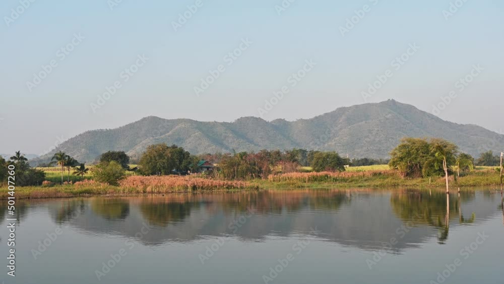Scenery of rustic house with mountain and blue sky reflection the water in Lam Thaphoen reservoir Scenery of rustic house with mountain and blue sky reflection the water in Lam Thaphoen reservoir
