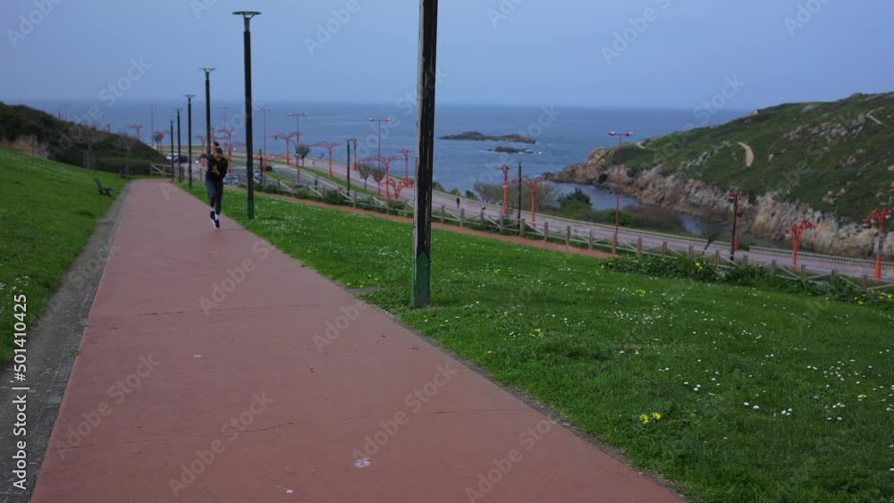 Girl athlete starts running on the street near the ocean Girl athlete starts running on the street near the ocean