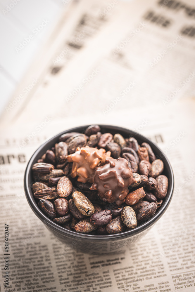 Cocoa beans and chocolate truffles in bowl. Sweet pralines. Cocoa beans and chocolate truffles in bowl. Sweet pralines.