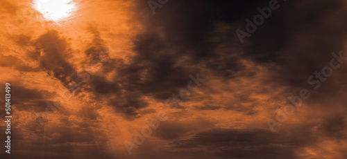Tableau sur toile Dramatic stormy sky in orange tones, with the sun and rays breaking through