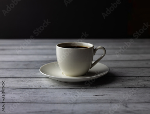 A cup of coffee  tea on a wooden table on black background