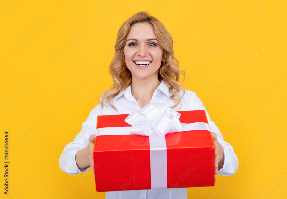 smiling woman with big present box on yellow background smiling woman with big present box on yellow background