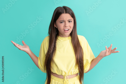 unpleased teen girl with long hair on blue background, teenage photo