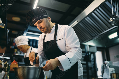 Professional male cook preparing food at restaurant kitchen.