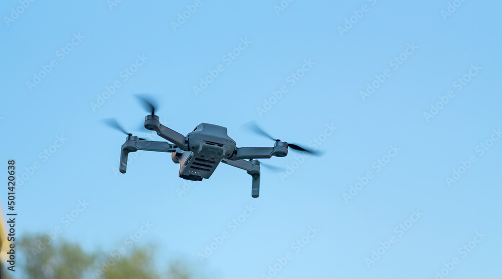 Consumer drone with camera hovering against sky with copy space Consumer drone with camera hovering against sky with copy space