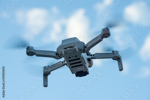 Consumer drone with camera hovering against sky