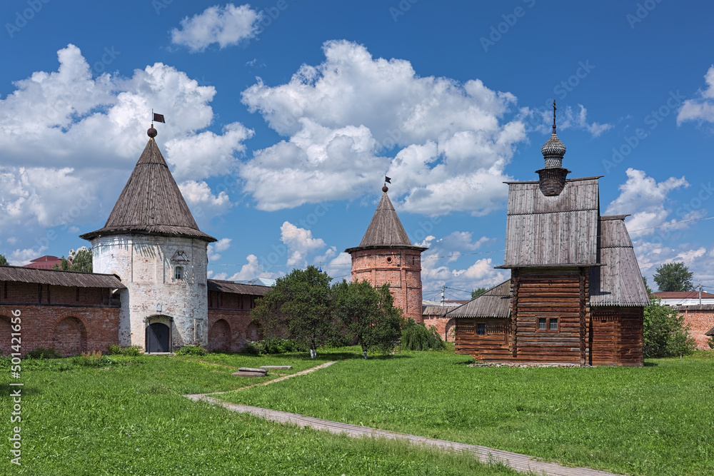 Yuryev-Polsky, Russia. Towers of fortified wall of Archangel Michael Monastery and wooden church of St. George. The monastery was founded in the 13th century. The church was built in 1718.