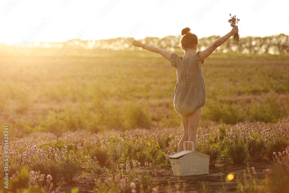 cute little girl in the meadow on sunset on summer day. child with basket in lavender field cute little girl in the meadow on sunset on summer day. child with basket in lavender field