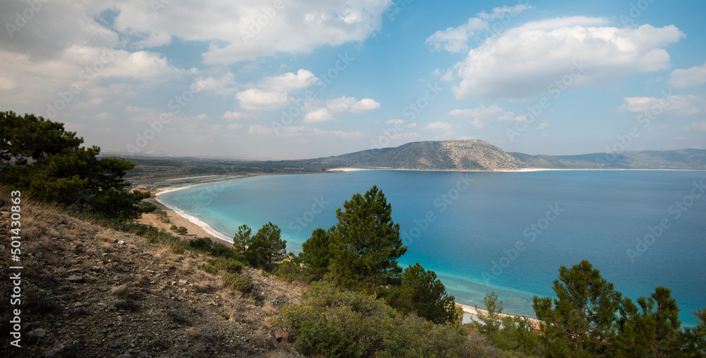 Fototapeta premium Calm view of a beautiful lake. Clouds and hills reflected in the turquoise lake waters.