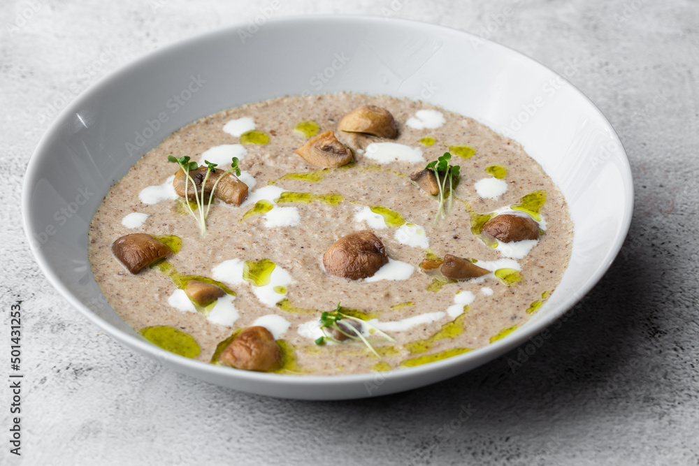 A bowl of Mushroom Cream Soup with fried champignons. Winter, autumn hot soup concept A bowl of Mushroom Cream Soup with fried champignons. Winter, autumn hot soup concept
