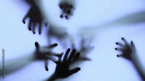 Silhouette of a zombie hand on white background in slow motion
 photo