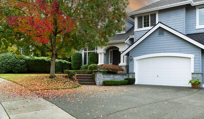 Early autumn residential single family home with colorful tree and sky