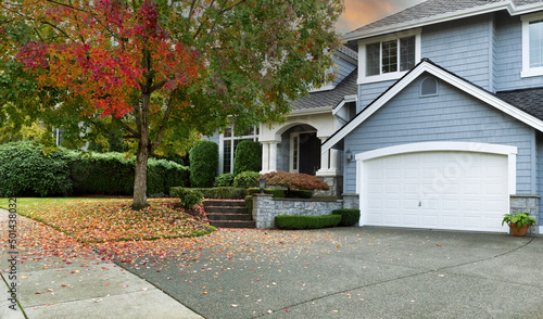 Early autumn residential single family home with colorful tree and sky