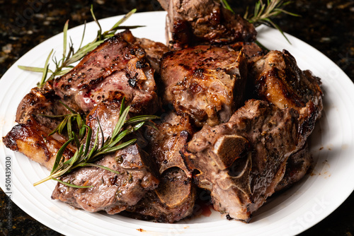 Cooked lamb loin chops with rosemary in a plate.