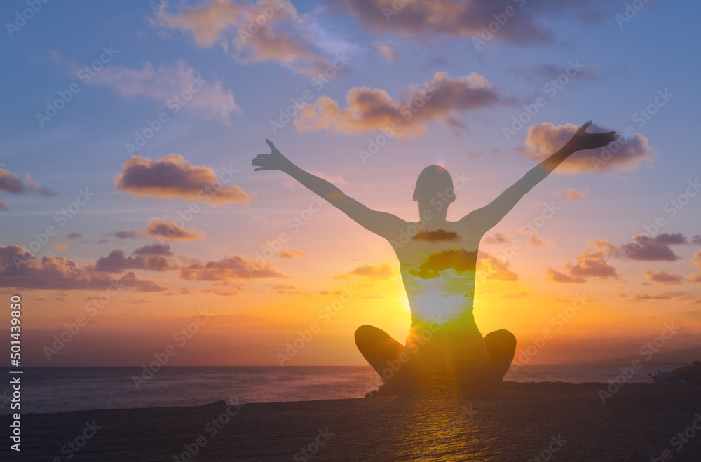 Happy woman with arms up to the sunrise expressing feelings of happiness, and thankfulness 