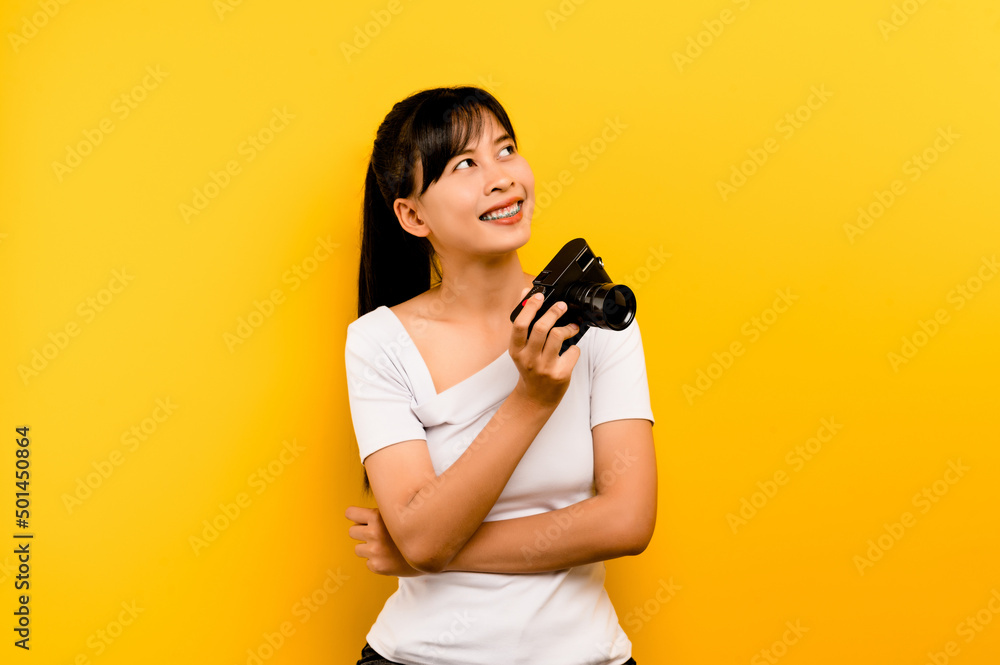 Photographer girl taking pictures. Isolated model on yellow background. with copy space Photographer girl taking pictures. Isolated model on yellow background. with copy space
