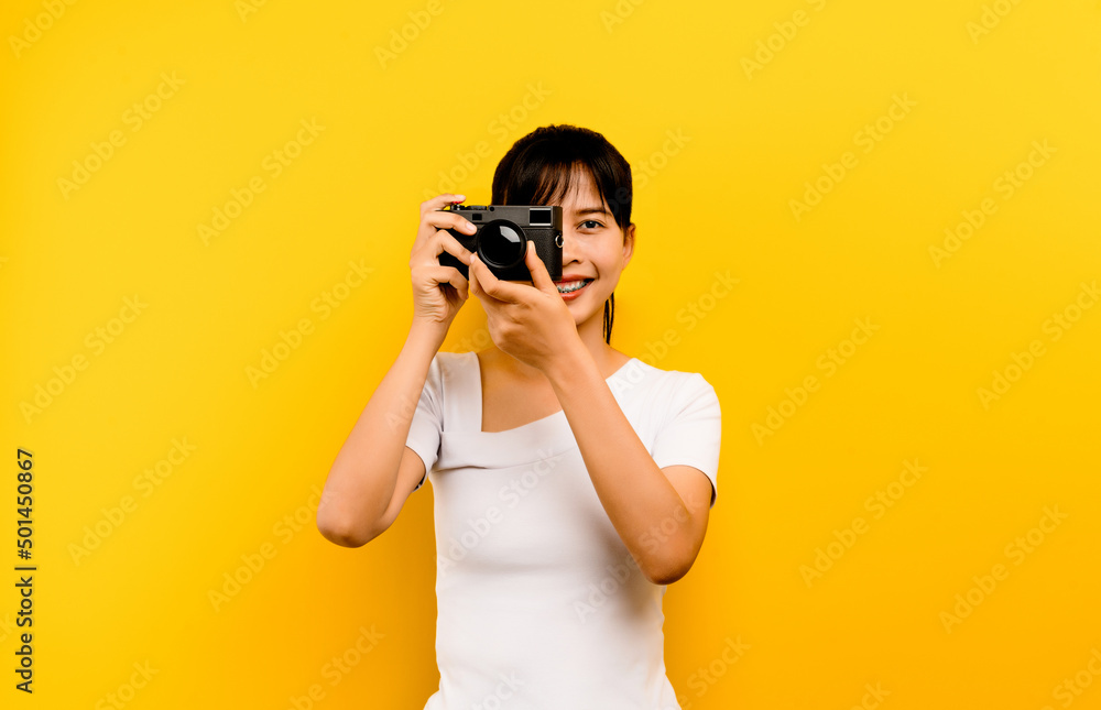 Photographer girl taking pictures. Isolated model on yellow background. with copy space Photographer girl taking pictures. Isolated model on yellow background. with copy space