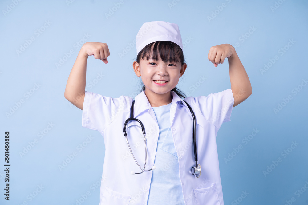 Image of Asian child wearing doctor uniform on blue background Image of Asian child wearing doctor uniform on blue background