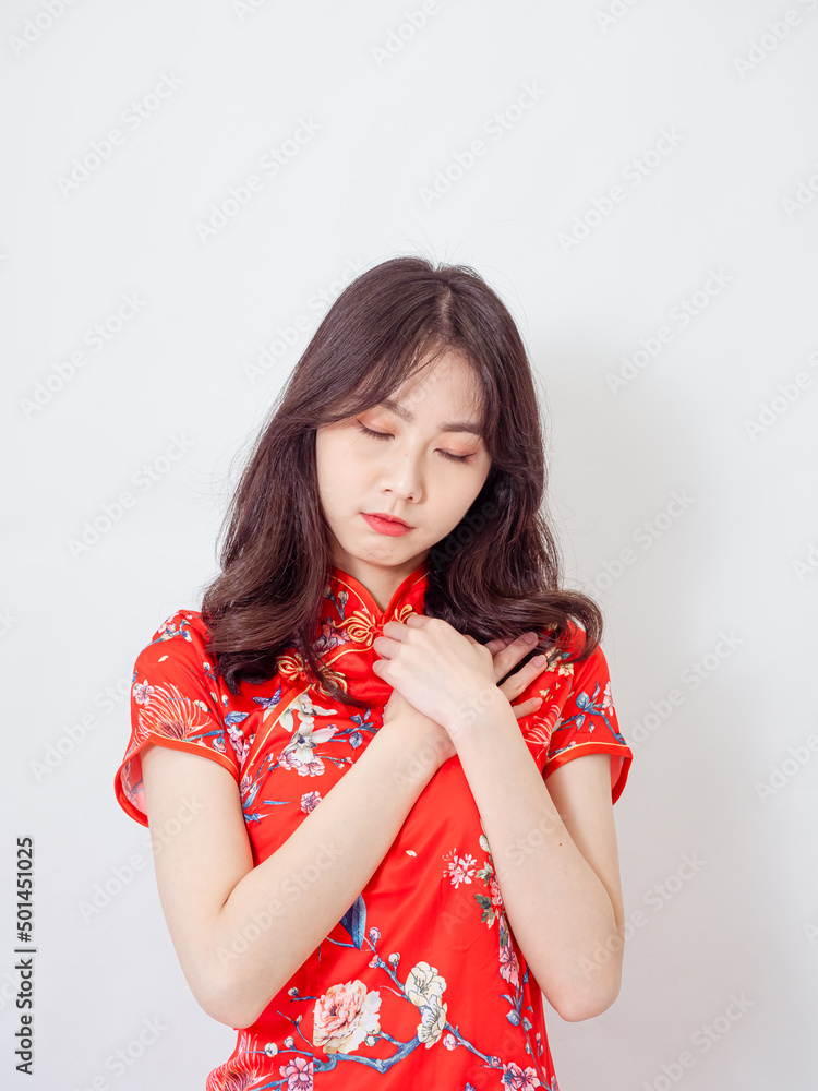 Young asian woman wearing traditional cheongsam qipao dress with hands on chest over isolated white background. Young asian woman wearing traditional cheongsam qipao dress with hands on chest over isolated white background.