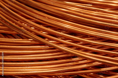 Large bobbin of orange copper wire in light warehouse