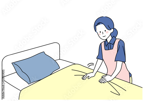 ベッドメイクをする介護士女性