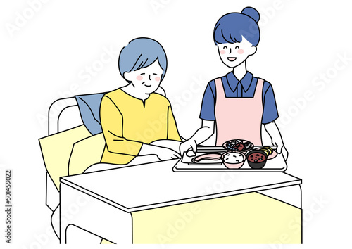 食事を運ぶ介護士女性