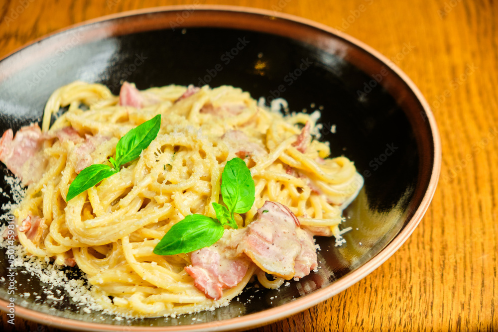 Italian recipe Pasta tortilloni with green pea, mint leaves, cheece, smoked bacon and cheese. Top view, blue background Italian recipe Pasta tortilloni with green pea, mint leaves, cheece, smoked bacon and cheese. Top view, blue background