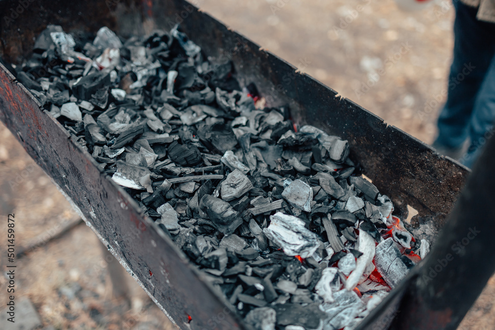 Burning charcoal in the grill. Outdoor recreation. Cooking outside on an open fire.j Burning charcoal in the grill. Outdoor recreation. Cooking outside on an open fire.j