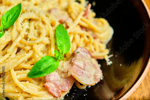 Italian recipe Pasta tortilloni with green pea, mint leaves, cheece, smoked bacon and cheese. Top view, blue background photo