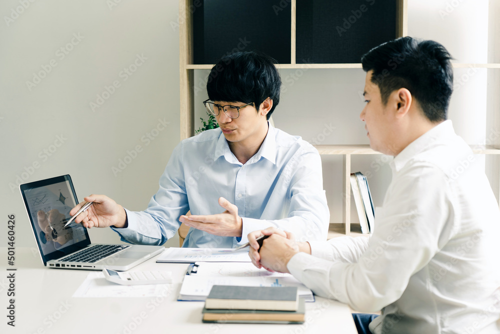Fototapeta premium Businessman explaining numeric graphs on computer to colleagues.