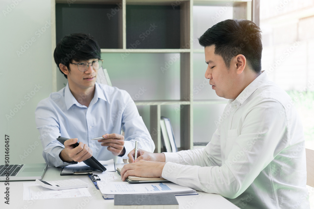 Businessman explaining to colleagues a graph of financial budget figures in a tablet. Businessman explaining to colleagues a graph of financial budget figures in a tablet.