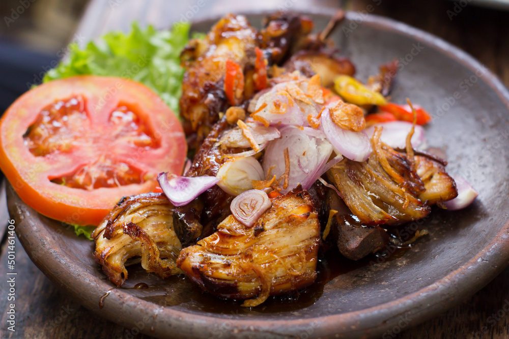 Traditional soy sauce grilled chicken served on an earthen plate