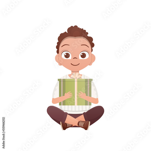 A little teen boy sits in a lotus position and holds a box with a bow in his hands. Birthday, New Year or holidays theme. Isolated. Cartoon style.