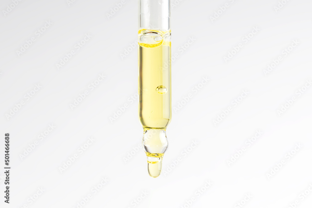 Cosmetic pipette with vitamin C serum or essential oil on light background. Skin care anti-aging treatment. Cosmetic pipette with vitamin C serum or essential oil on light background. Skin care anti-aging treatment.