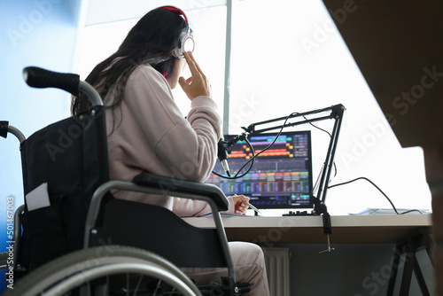 Fotobehang Woman in wheelchair with headphones in front of microphone and computer