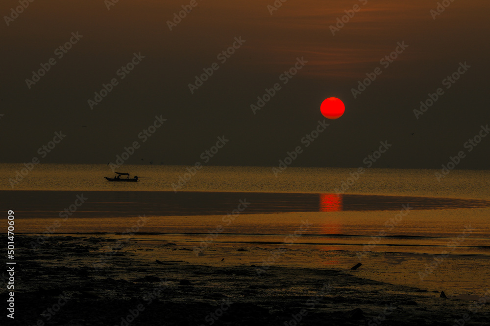 The blurred background of the morning twilight by the sea, changing the color of the beautiful sky, there is a fishing boat docked waiting to go out to find fish again. The blurred background of the morning twilight by the sea, changing the color of the beautiful sky, there is a fishing boat docked waiting to go out to find fish again.