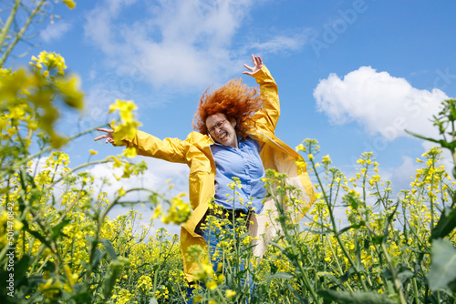 A woman jumping in the field and having fun after the rainy summer day