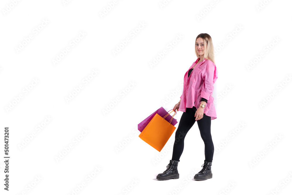 Young woman standing posing with shopping bags in her hand looking at camera Young woman standing posing with shopping bags in her hand looking at camera