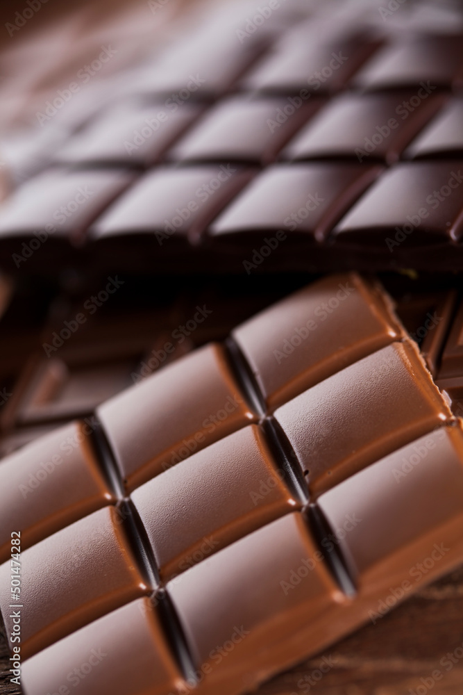 Obraz premium Dark homemade chocolate bars and cocoa pod on wooden