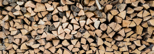 Background of stacked chopped wood logs. Pile of wood logs ready for winter. Wooden stumps  firewood stacked in heap