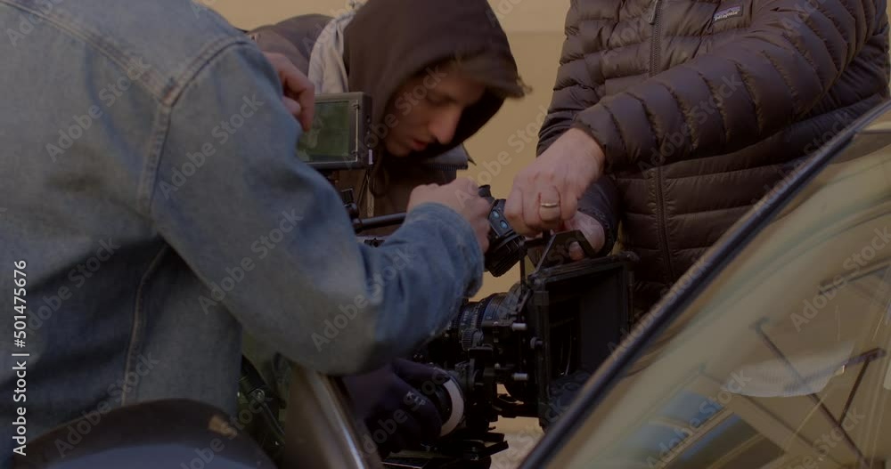 The film crew prepares the camera for use. The actor is in the car. Replacing an element. Back stage movie scenes. Glare and reflections on glass. CZ, Prague, Myslikova, 23.2.2022 The film crew prepares the camera for use. The actor is in the car. Replacing an element. Back stage movie scenes. Glare and reflections on glass. CZ, Prague, Myslikova, 23.2.2022