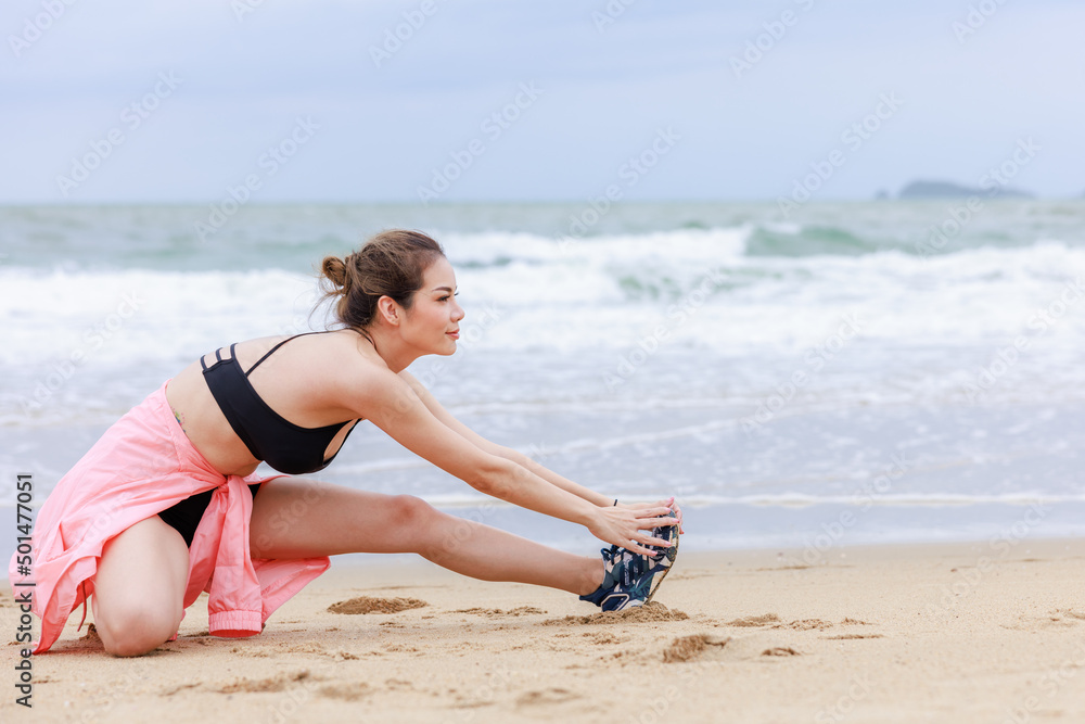 asian woman in sport wear and pink jacket exercise on the beach at evening in the rain season asian woman in sport wear and pink jacket exercise on the beach at evening in the rain season