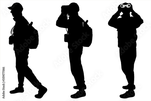 Man, the boy in a hat, climber with a backpack on his back standing, looking through binoculars. Tourist with the binoculars in hands. Orientation to districts. Male silhouette. Side view, full face.