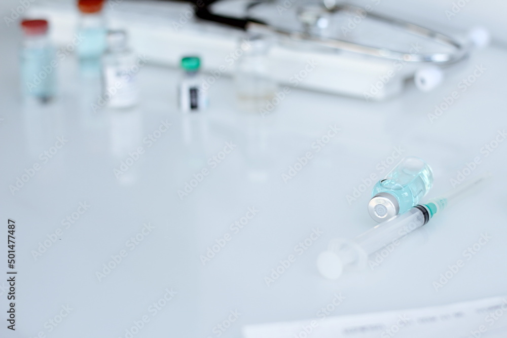 Vaccine bottle and syringe placed on a white table. Healthcare and medical concept. Vaccine bottle and syringe placed on a white table. Healthcare and medical concept.