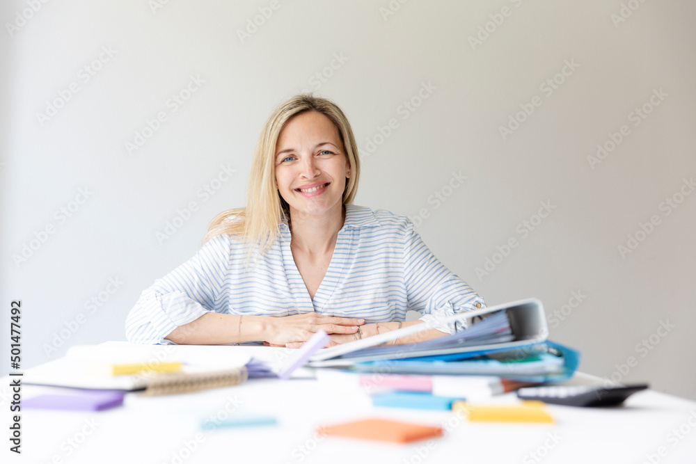 Businesswoman is sitting in bright modern office behind her desk on which many office things are lying and relaxing, sleeping and thinking Businesswoman is sitting in bright modern office behind her desk on which many office things are lying and relaxing, sleeping and thinking