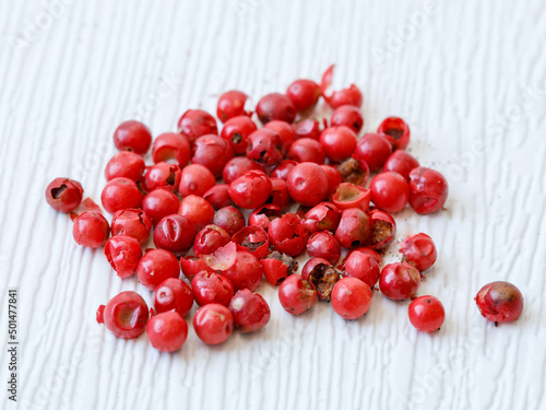 handful of dried pink peppercorn close-up, spice or seasoning as background. Dry berries of Schinus molle or Schinus terebinthifolius. Food background, full frame, copy space photo