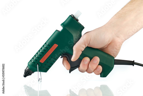 Electric hot glue gun in hand, isolated on white.